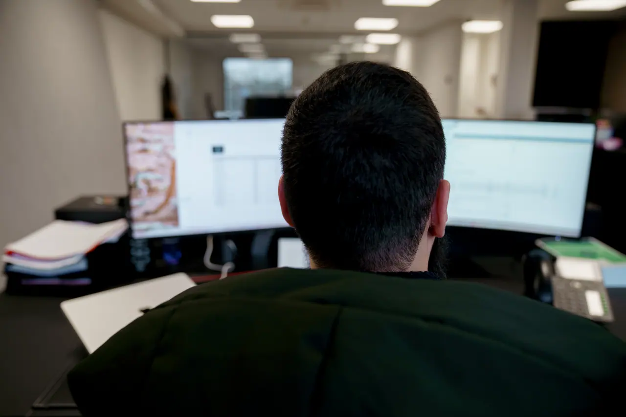 Een medewerker van FK Boekhouding aan twee schermen, van achteren gezien