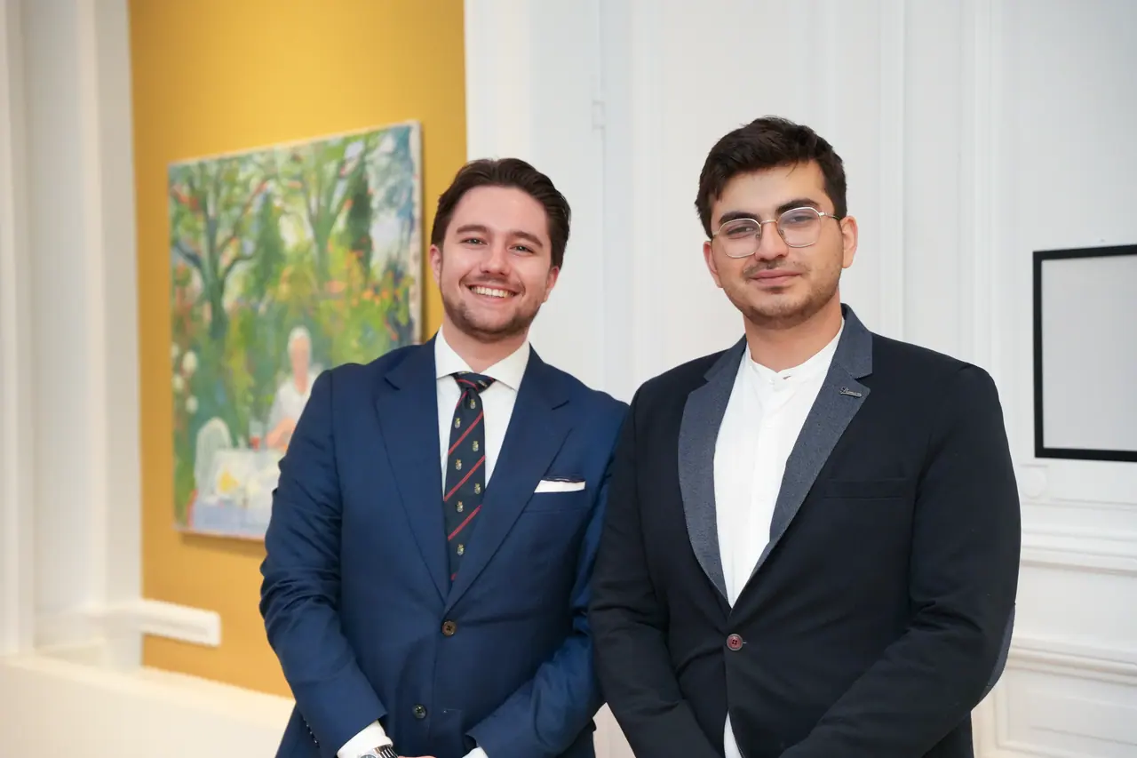 Two K&A Law lawyers laughing in front of a painting