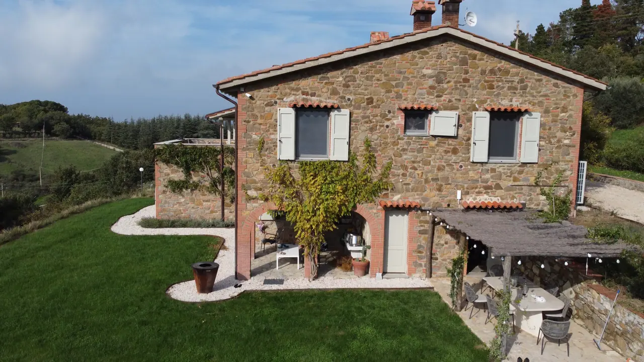 Aerial view of the stone villa with lawn and pergola