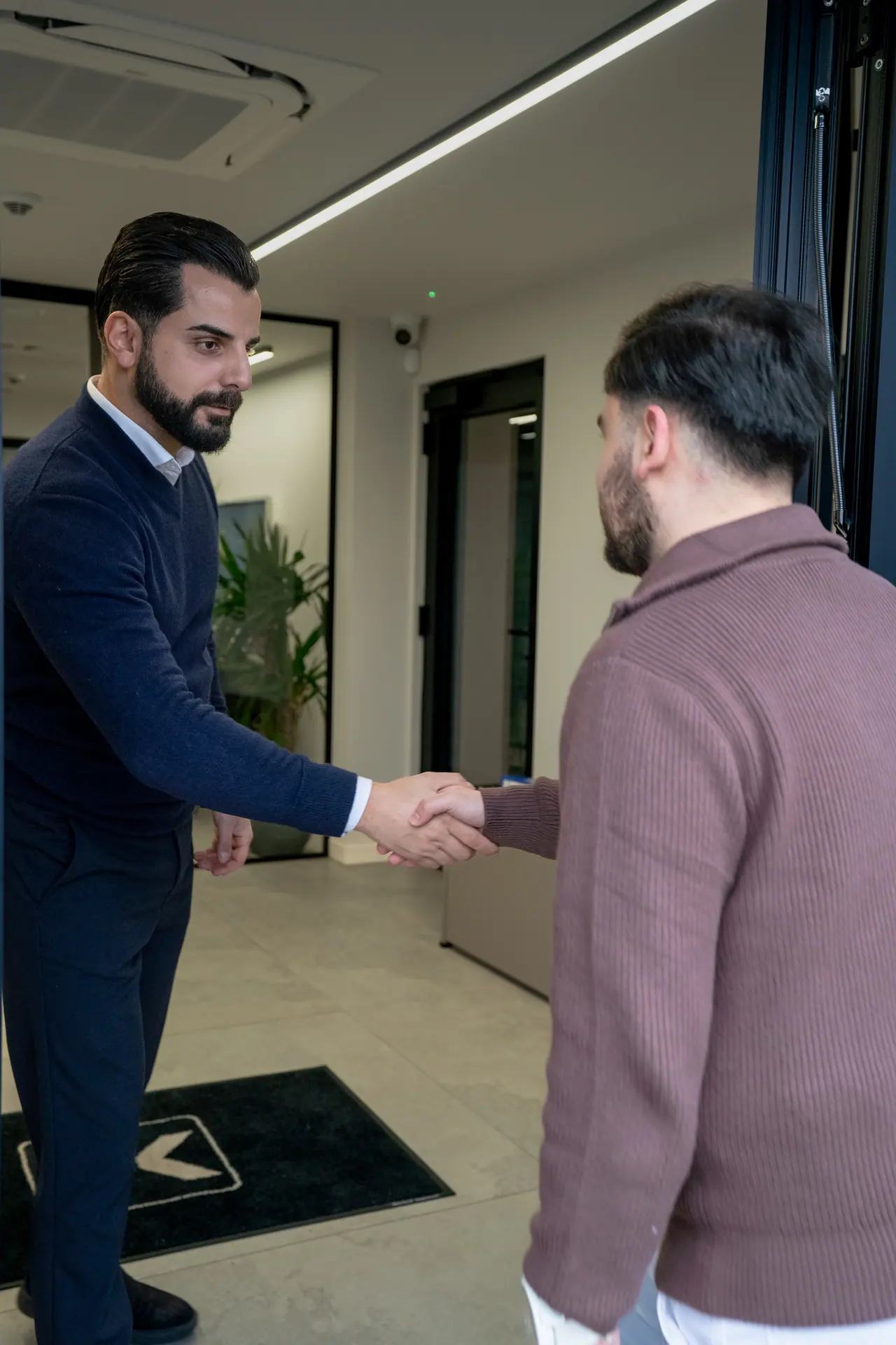 Een medewerker van FK Boekhouding verwelkomt een klant aan de inkom