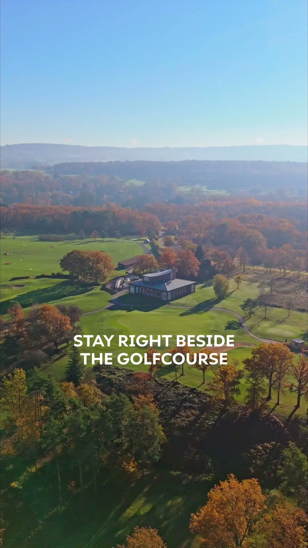 Een beeld uit de golfreel voor Les Terrasses de Durbuy, met een lodge tussen herfstbomen en de tekst Stay right beside the golfcourse
