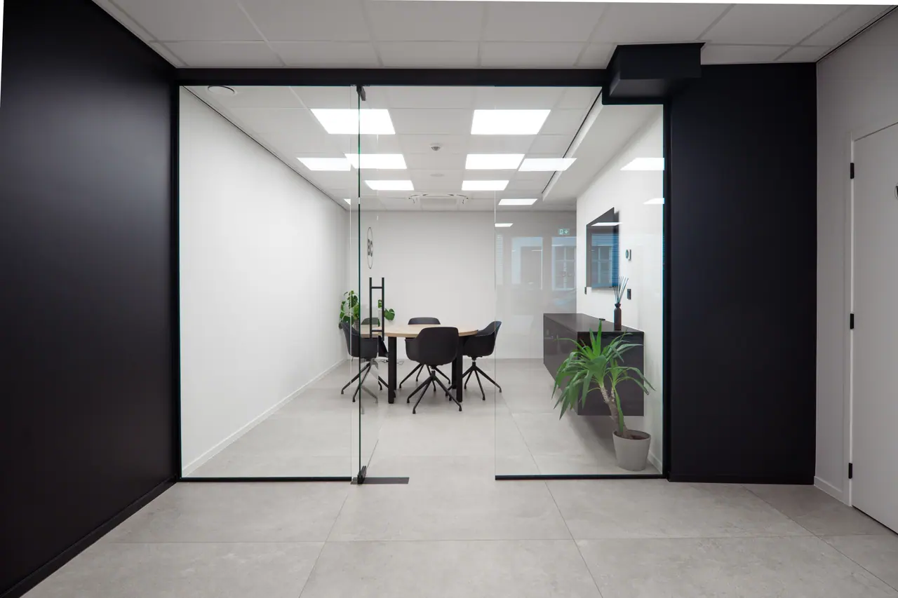 Een lege vergaderzaal met een glazen wand en een lange tafel, de plek waar je het AI-beleid voor je bedrijf afspreekt