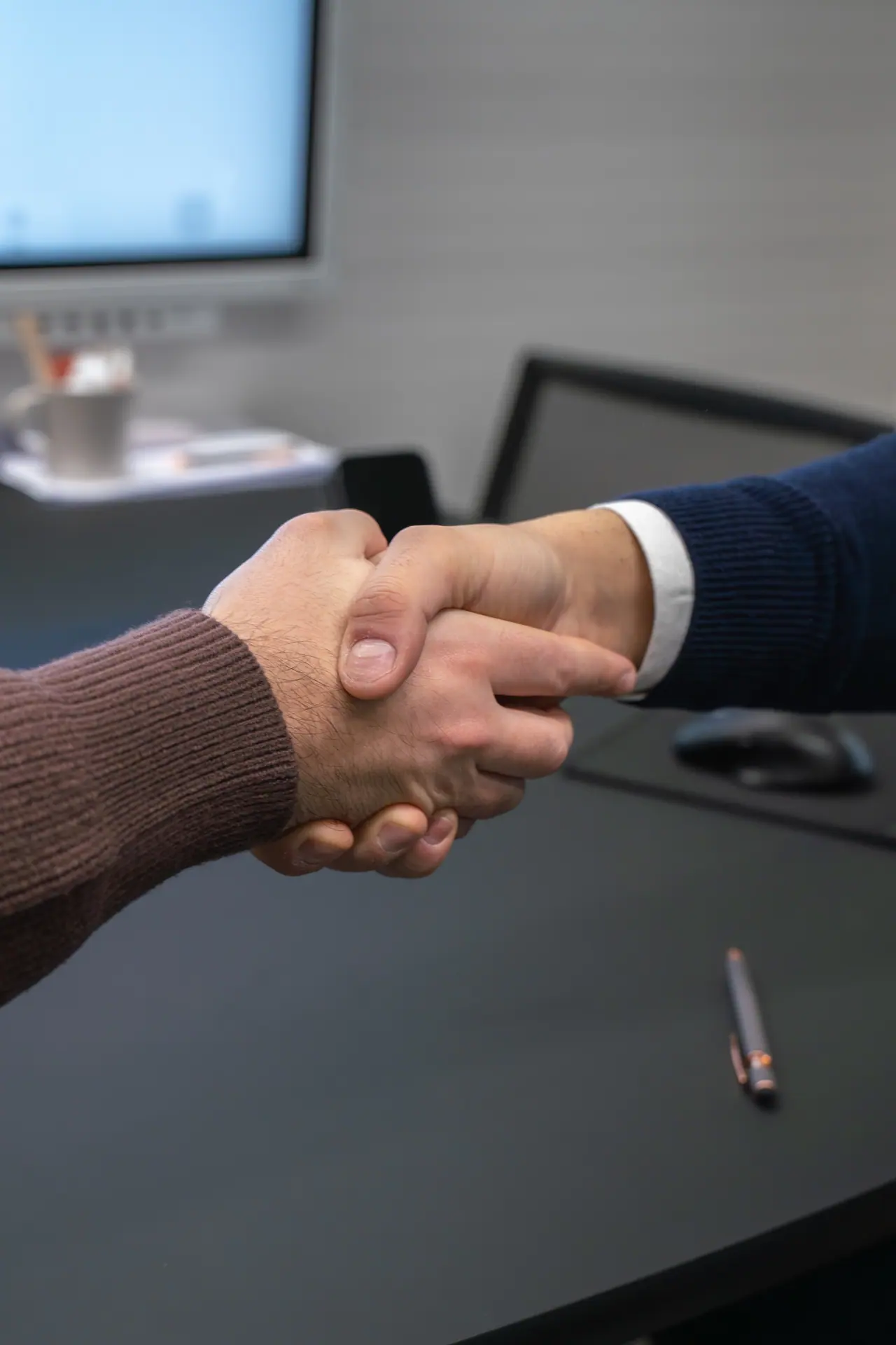 Odoo or custom software: a handshake at the desk after agreeing on the next phase of a build