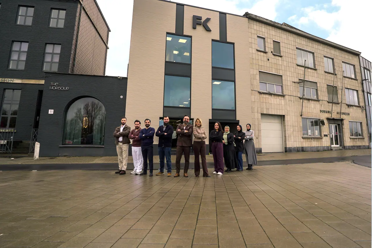Een team voor zijn kantoorgebouw met logo, breed gefotografeerd vanaf het plein: het soort foto voor wie een Google Bedrijfsprofiel aanmaakt