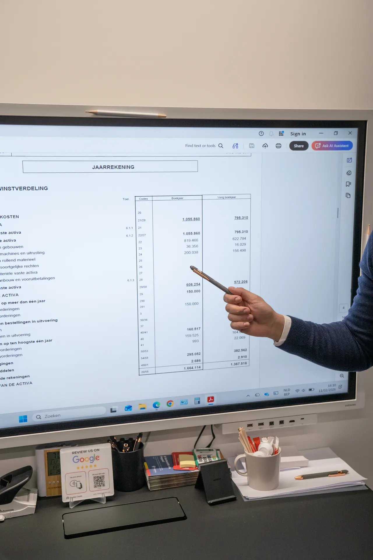 Software laten ontwikkelen en de kosten bespreken: iemand wijst met een pen naar een tabel op een groot scherm
