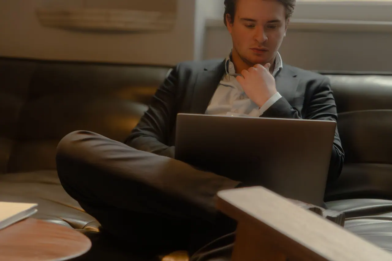 Een collega van VBS werkt op zijn laptop in een loungezetel