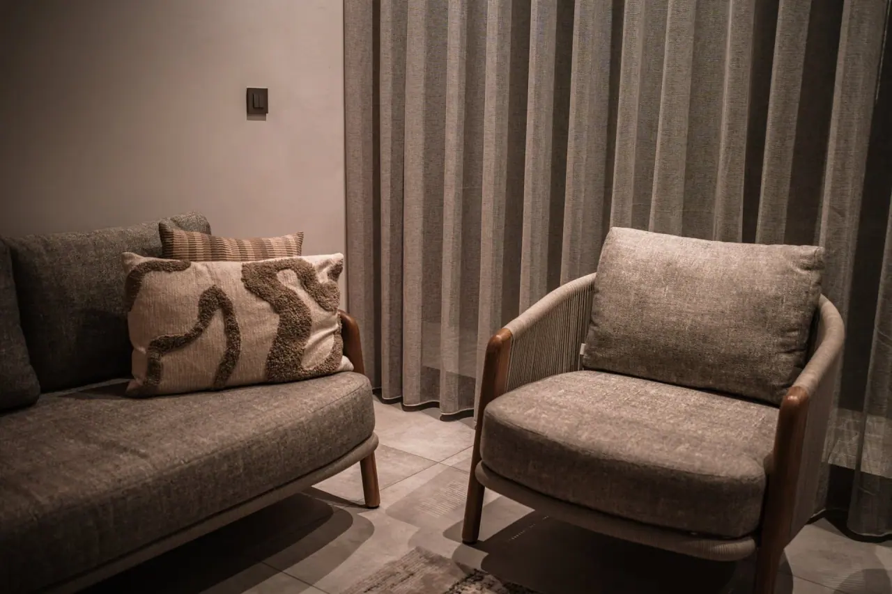 A finished SN Group seating area with a sofa, an armchair and long curtains