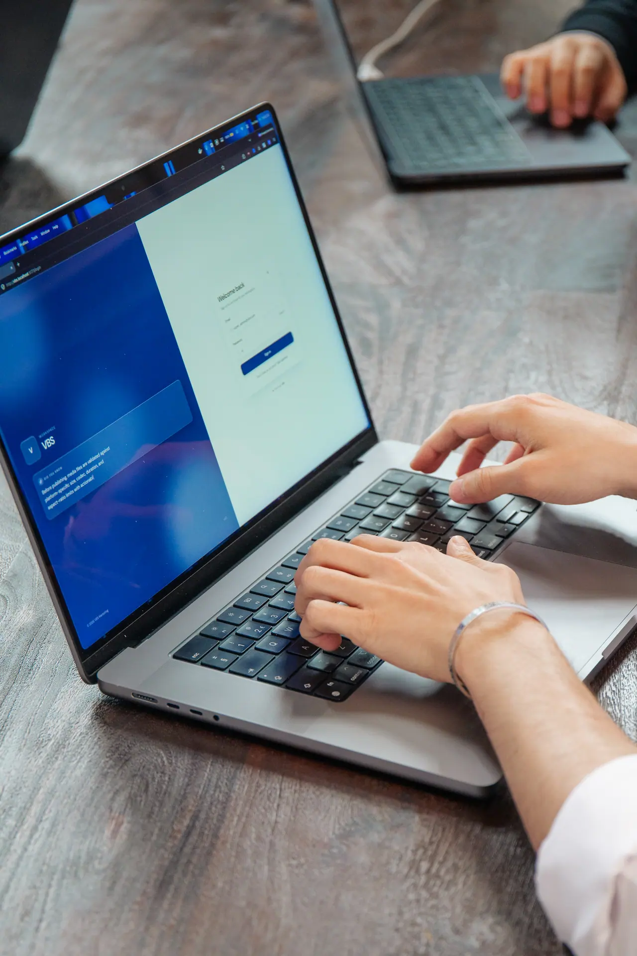 Handen op een laptop aan de vergadertafel van ons kantoor