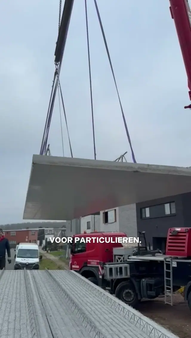 Een vloerplaat hangt aan de kraan boven een werf van SN Group, uit een reel die we maakten